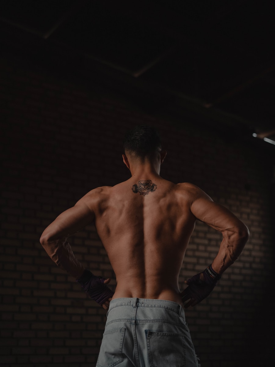 A man standing in a dark room with his back to the camera