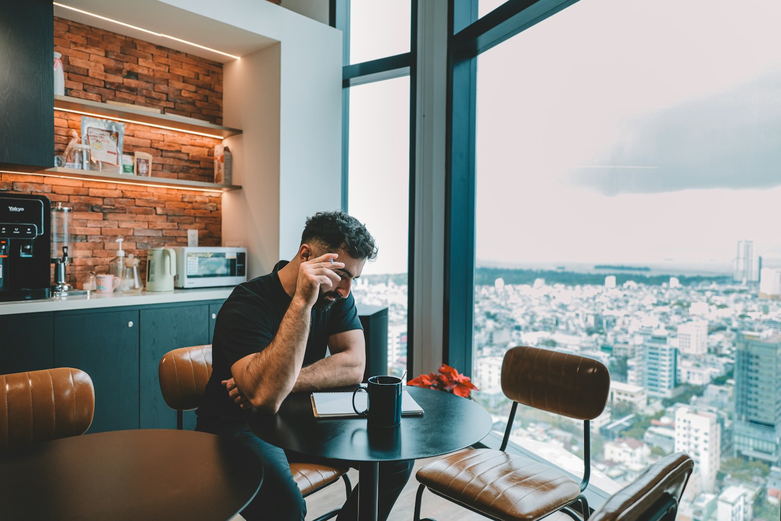 Man sitting at a table with city view.